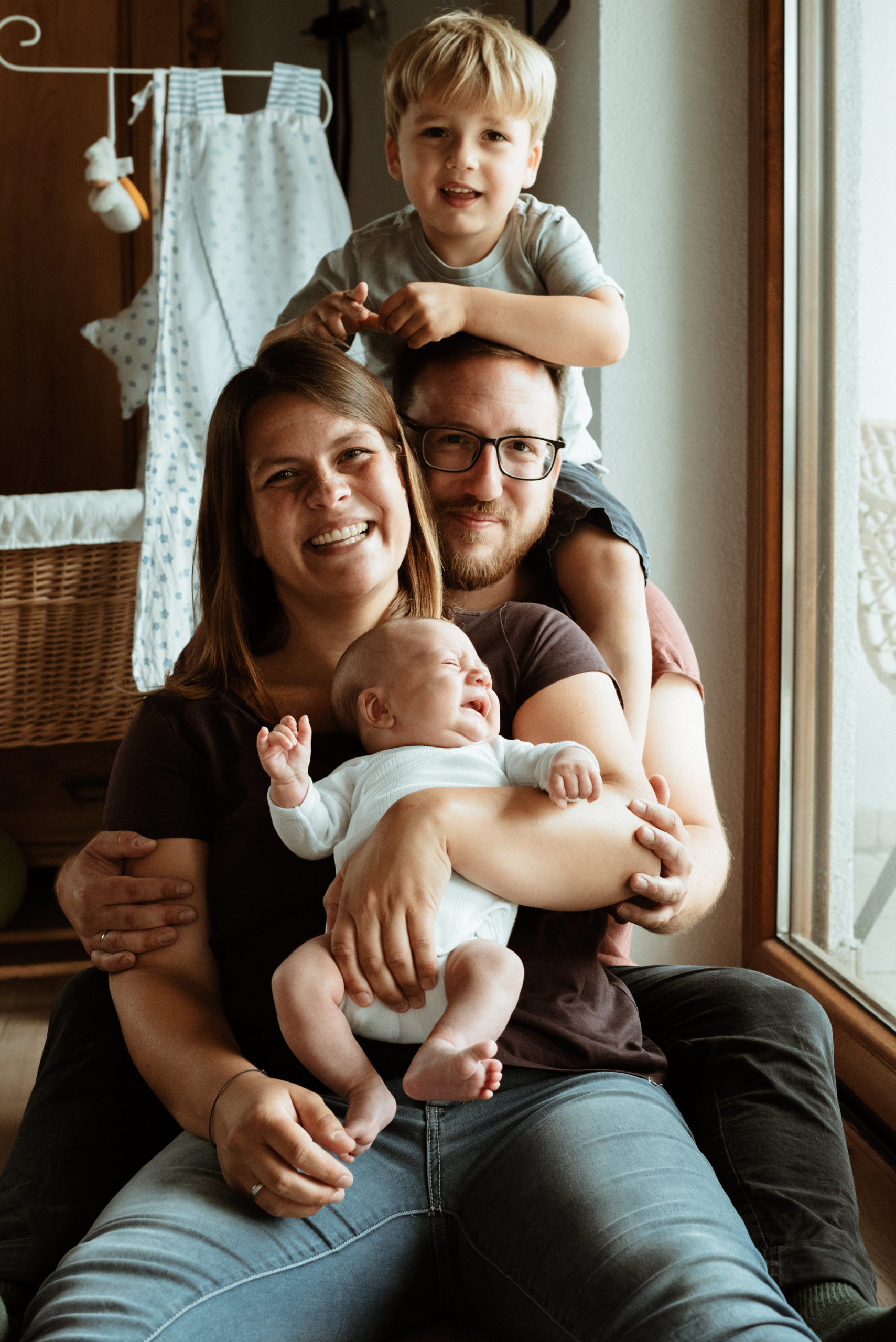 Familienfoto der ganzen Bande: Mama, Papa und die zwei Söhne bei diesem Neugeborenen Fotoshooting in Nürnberg.